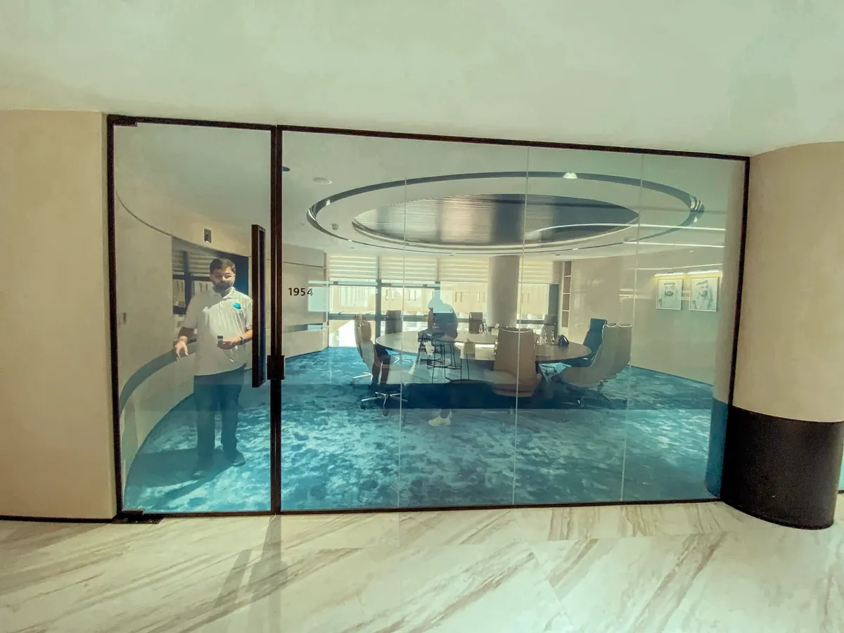 Glass-walled meeting room with slim black frames in an office